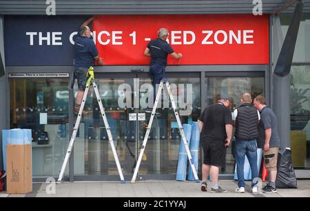 Workmen place signs at main entrance to the Etihad Stadium, home of Manchester City. The Premier League restarts tomorrow night with Aston Villa v Sheffield United and Manchester City v Arsenal. Stock Photo