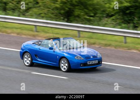 2004 blue MG TF 135 Cool Blue; Vehicular traffic moving vehicles, cars driving vehicle on UK roads, motors, motoring on the M6 motorway Stock Photo