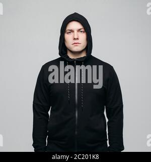 Handsome man in black hoodie posing at camera. Stock Photo