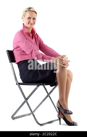 Portrait of mature realtor woman sitting on a black chair, on white background Stock Photo