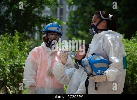 (200616) -- BEIJING, June 16, 2020 (Xinhua) -- Members of the Beijing Blue Sky Rescue(BSR) team take a rest after a disinfection operation at a community in Fengtai District in Beijing, capital of China, June 16, 2020. Beijing has strengthened community-level disease prevention and control in response to the resurgence of domestically transmitted COVID-19 cases. (Xinhua/Chen Zhonghao) Stock Photo