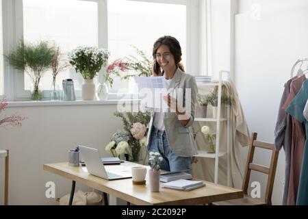 Smiling female designer talk on cellphone with client Stock Photo