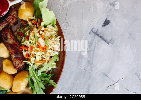 Clay plate full of tasty appetizers for beer standing on white table. Stock Photo