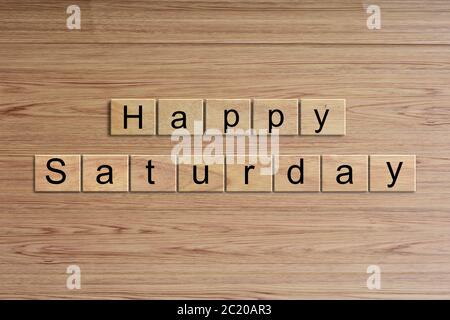Happy Saturday word written on wood block. Message text on wooden table for backdrop design. Stock Photo