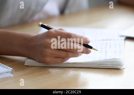 Close up of woman handwriting in notebook studying at home Stock Photo