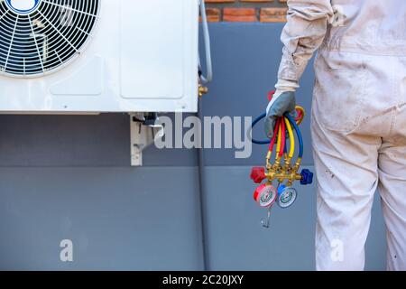 Air conditioning repairman carrying tools, gauges for measuring liquid and pressure Stock Photo