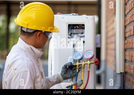 Air conditioning technician is checking the compressor with gauge Stock Photo