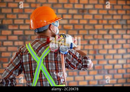 Air conditioner technician ready to work with a gauge miter Stock Photo