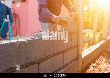 Masons constructing masonry to build fences Stock Photo