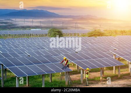 Engineering team inspecting or repairing solar cells on solar farms. Stock Photo