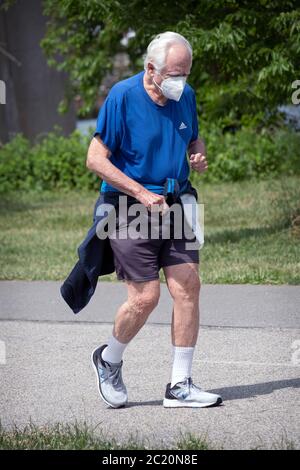 An older male likely in his 80's or older runs slowly on a path in Little Bay Park, Whitestone, Queens, NYC. Stock Photo