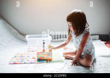 Kid enjoy playing the lego create building construction model stay at home Stock Photo
