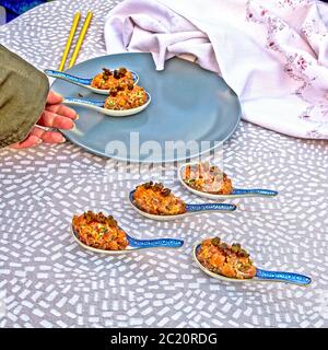 Specialty salmon meat with spices on the table. The meat is decoratively presented in ceramic spoons. Stock Photo