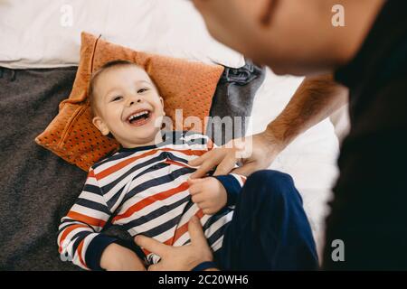 Caucasian father and son having fun on the sofa together during the weekend laughing happy to camera Stock Photo