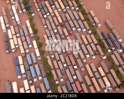 Drone aerial view top shot of row of trucks transporting soybeans in BR 163 road gas station garage on Amazon, Para, Brazil. Concept of transportation Stock Photo