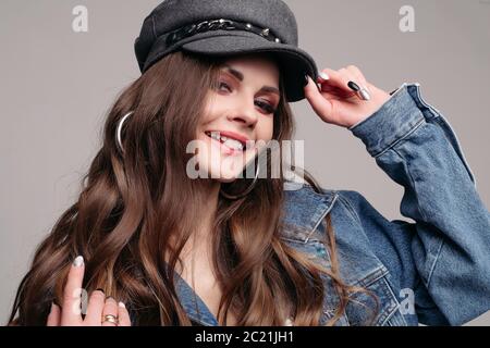 Fashionable pretty brunette girl in stylish hat and denim jacket. Stock Photo