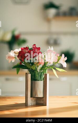 a vase of flowers in the rays of sunlight Stock Photo