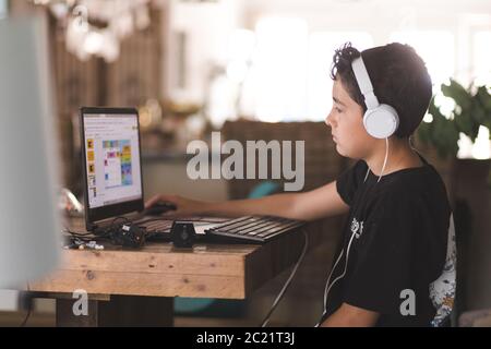 Boy doing his homework on laptop Stock Photo