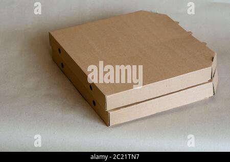 Cardboard boxes for pizza close-up. Two closed brown boxes in a stack. Food packaging and delivery. Courier service. Close-up. Selective focus. Stock Photo