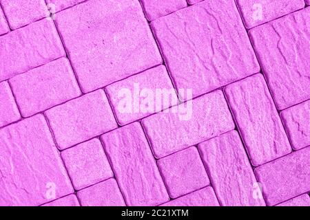 Highly detailed street pavement background with diagonal geometric pattern made of various square blocks with textured rough surface toned in pink pur Stock Photo