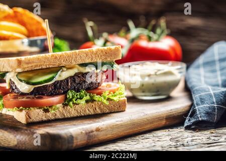Minced beans vegetarian toast with lettuce, tomato and cucumber surrounded by rustic wood Stock Photo