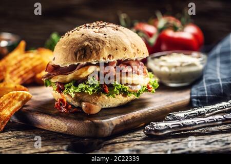 Double cheese burger with bacon and lettuce in a sesame bun Stock Photo