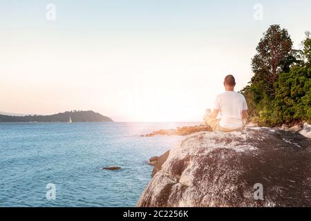 Young Man Meditating on beach. Stock Photo