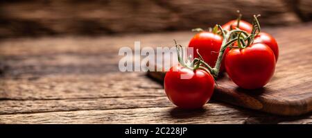 Bunch of fresh tomatoes on a rustic wooden surface Stock Photo