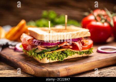 BLT sandwich with onion on a cutting board with a dark background Stock Photo