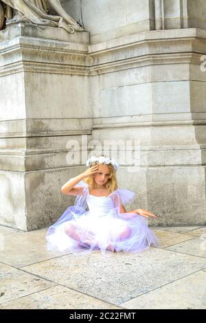 Girl ballerina Paris sitting on a old stone background. Beautiful model. Happy dancing people. Love fashion. Stock Photo