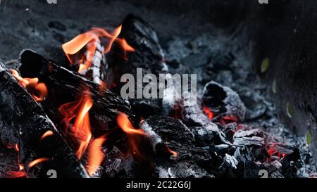 Black coals with fire and sparks in the grill. Preparation for cooking kebabs. Stock Photo