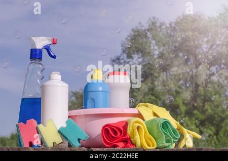 Home cleaning products with colorful napkins, sponges on a blue sky background with soap bubbles. Spring cleaning, the prevention of viral diseases. C Stock Photo