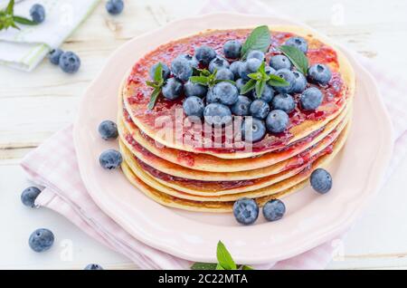 delish breakfast with fresh fruit on garden party, outside with flowers behind and fresh herbs on top Stock Photo