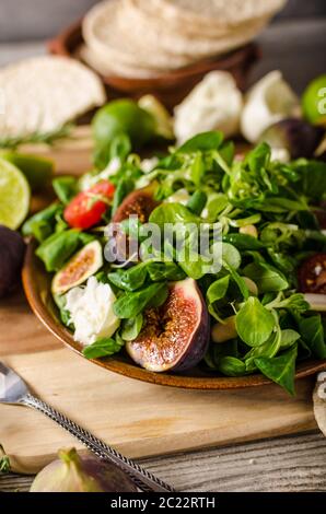 Delicious figs salad with tomatoes, lamb lettuce, cheese and homemade naan bread Stock Photo