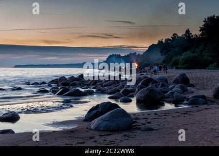 Unrecognisable people celebrating summer solstice with bonfires on beach Stock Photo