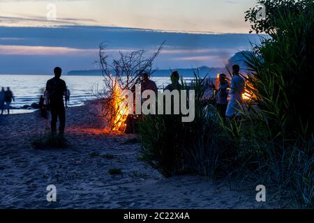 Unrecognisable people celebrating summer solstice with bonfires on beach Stock Photo