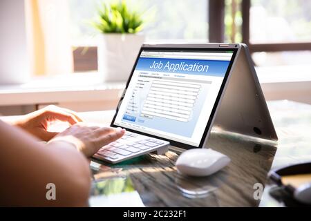 Close-up Of Businesswoman Filling Online Job Application Form On Laptop Stock Photo