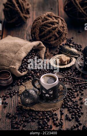 Traditional Turkish Coffee in a ceramic coffee mug covered with copper pot Stock Photo