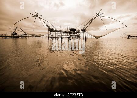 Old photo in sepia warm two tone vintage style, landscapes of Songkhla Lake and fishing square dip net is a local fishing tool rural lifestyle at Pakp Stock Photo