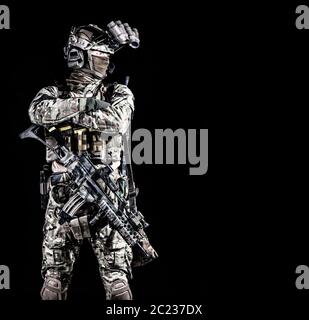 Modern combatant, army special forces soldier, counter terrorist squad mender in full ammunition, hiding face behind mask, equipped night vision devic Stock Photo
