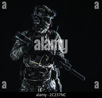 US marine riders shooter, army special forces soldier standing in darkness in mask, battle uniform, quad-tube, four lenses night vision goggles on hel Stock Photo