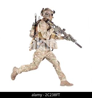 Army soldier, equipped infantryman, airsoft player in camouflage battle uniform, helmet and tactical radio headset jumping, running with assault rifle Stock Photo