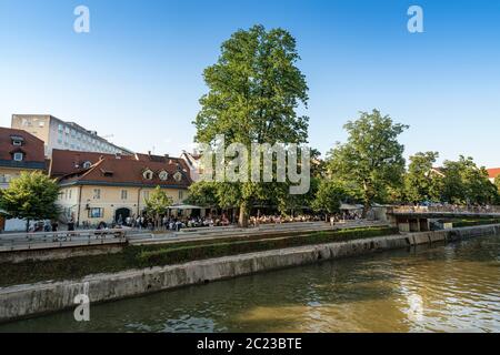 Ljubljana, Slovenia. August 3, 2019. the sight of people in outdoor cafes along the shore  of the river Ljubljanica in the city center Stock Photo