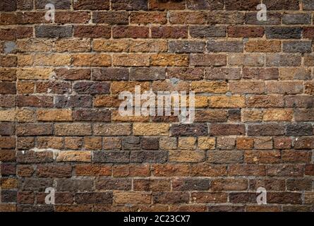 Mixed rustic brick background, rough texture backdrop in shades of brown and yellow ochre, creative copy space, horizontal aspect Stock Photo