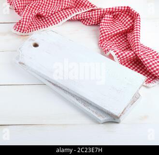 rectangular empty wooden cutting boards and red towel, white table Stock Photo