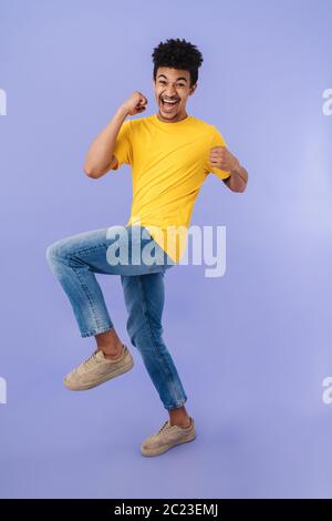 Photo of joyful african american man laughing and making fun at camera isolated over purple background Stock Photo