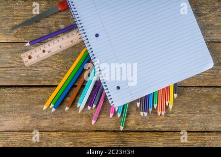 Assortment of colored pencils, ruler, glue and scissors on table Stock Photo