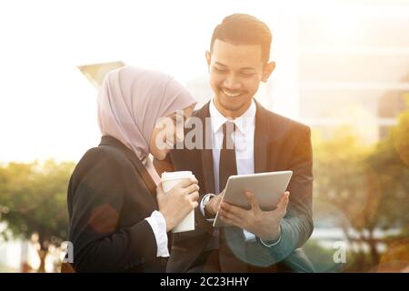 Business team discussing, using tablet pc outside office. Stock Photo