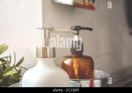 Two soap dispensers in a light room with natural sunlight. Stock Photo