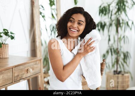Home Haircare. Smiling African Woman Drying Wet Hair With Towel After Shower Stock Photo